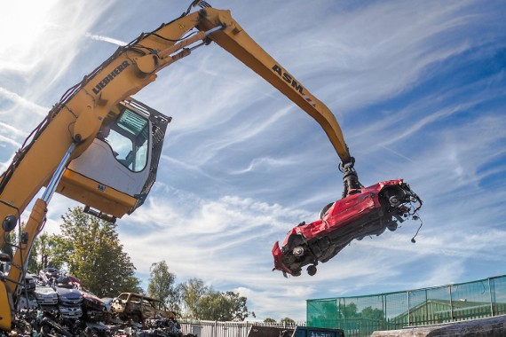 Una gru per la rottamazione delle auto al lavoro